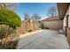 Concrete backyard patio with a wood fence, brick accents, and green foliage at 3875 Offshore Dr, Columbus, IN 47203