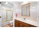 Bathroom with floral wallpaper, wood cabinets, and shower at 3875 Offshore Dr, Columbus, IN 47203