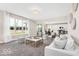 Bright living room boasts large windows, neutral decor, and seamless flow to the dining area at 4777 E Summerfield Dr, Camby, IN 46113