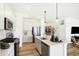 Modern kitchen featuring stainless steel appliances, a spacious island with pendant lighting, and sleek white cabinetry at 5035 Astor Ct, McCordsville, IN 46055