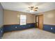 Bedroom with neutral carpet, wainscotting, and a ceiling fan at 5371 Lue Ann Ln, Mooresville, IN 46158