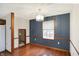 This dining room features a modern chandelier, blue accent wall with white trim and a window at 5371 Lue Ann Ln, Mooresville, IN 46158