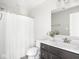Bright bathroom with a dark wood vanity, white countertops, and a shower with a white curtain at 5832 Lyster Ln, Indianapolis, IN 46239