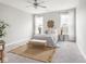 Serene primary bedroom features neutral color palette, plush carpeting, accent rug, and natural light through large windows at 5832 Lyster Ln, Indianapolis, IN 46239