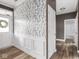Inviting hallway with decorative wallpaper and wainscoting that leads to a bathroom at 5832 Lyster Ln, Indianapolis, IN 46239