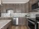 Open concept kitchen with stainless steel appliances, gray subway tile backsplash, and stylish cabinetry at 5832 Lyster Ln, Indianapolis, IN 46239