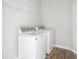 Convenient laundry room with side-by-side washer and dryer, white shelving, and durable wood-look flooring at 5832 Lyster Ln, Indianapolis, IN 46239