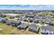 Expansive aerial view of a residential community, showcasing neatly arranged homes, streets, and a pond at 6075 Meadowview Dr, Whitestown, IN 46075