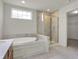 Bright bathroom featuring a soaking tub and glass-enclosed shower at 6075 Meadowview Dr, Whitestown, IN 46075