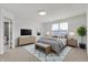 This bright bedroom includes a queen bed, a gray rug with a blue pattern, and an ensuite bathroom on the left at 6075 Meadowview Dr, Whitestown, IN 46075