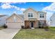 Beige two-story house with a two-car garage, brick accents, and a well-maintained lawn at 6075 Meadowview Dr, Whitestown, IN 46075