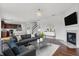 A living room displays a fireplace, gray couches with blue accents, and hardwood flooring throughout the main level at 6075 Meadowview Dr, Whitestown, IN 46075