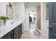 Bathroom featuring dual sinks, dark wood cabinetry with gold hardware, and a tiled shower stall at 6345 Meadowview Dr, Whitestown, IN 46075