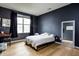 Stylish bedroom with dark blue walls, light hardwood floors, and a modern minimalist design at 6345 Meadowview Dr, Whitestown, IN 46075