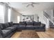 Open-concept living area with a large sofa, hardwood floors, and a view of the modern kitchen and staircase at 6345 Meadowview Dr, Whitestown, IN 46075
