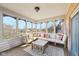 Relaxing sunroom featuring comfortable seating, a wooden floor, and a picturesque view of the lush surrounding landscape at 6516 Shamel Dr, Indianapolis, IN 46278
