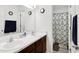 Bathroom with double sinks, brown vanity and shower with blue patterned curtain at 7517 Heben Dr, Indianapolis, IN 46113