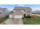 A charming two-story home boasts a three-car garage, brick accents, and beautiful landscaping at 7517 Heben Dr, Indianapolis, IN 46113
