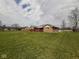 Expansive backyard with brick home, wooden deck, and neighboring houses in the distance at 791 W 500 S, Greenfield, IN 46140