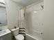 Well-lit bathroom featuring a shower-tub combo and stylish striped shower curtain at 8525 E 42Nd Pl, Indianapolis, IN 46226