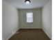 Compact bedroom with neutral carpet, a window offering light, and simple decor at 8525 E 42Nd Pl, Indianapolis, IN 46226