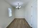 Dining room featuring modern light fixture, wood floors, a window, and a neutral color scheme at 8525 E 42Nd Pl, Indianapolis, IN 46226