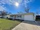 Charming single-story home with a well-maintained lawn, attached garage, and natural light on a sunny day at 8525 E 42Nd Pl, Indianapolis, IN 46226