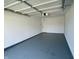 Clean garage with gray sealed floor, white walls, and door leading to home interior at 8525 E 42Nd Pl, Indianapolis, IN 46226