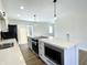 Modern kitchen features stainless steel appliances, a large island, and sliding glass doors to the backyard at 8525 E 42Nd Pl, Indianapolis, IN 46226
