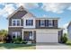 Charming two-story home featuring a brick and gray facade, with an attached two car garage and manicured front lawn at 9723 Violet Cir, Indianapolis, IN 46239