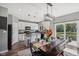 Open kitchen and dining area with modern lighting fixtures, sleek white cabinetry, and a view of the outdoor patio at 9723 Violet Cir, Indianapolis, IN 46239