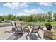 Cozy patio with outdoor seating and a fire pit, set against a tranquil pond backdrop with mature trees at 9723 Violet Cir, Indianapolis, IN 46239