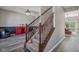 Carpeted staircase features wood railing and banister, with view of dining area with wood flooring at 9723 Violet Cir, Indianapolis, IN 46239