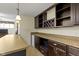 Close up of the basement bar featuring dark wood cabinets, granite countertops, and mini-fridge at 9931 Woodlands Dr, Fishers, IN 46037