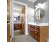 Modern bathroom with wood cabinets, sink and round mirror at 9931 Woodlands Dr, Fishers, IN 46037