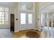 Elegant foyer with a decorative transom window over the front door and light hardwood floors at 9931 Woodlands Dr, Fishers, IN 46037