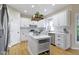 Modern white kitchen with an island, stainless steel appliances, and sleek countertops offers a functional and stylish design at 9931 Woodlands Dr, Fishers, IN 46037