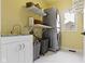 Efficient laundry room featuring a stacked washer and dryer, a sink with storage, and built-in shelving for organization at 9931 Woodlands Dr, Fishers, IN 46037