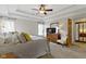 Spacious main bedroom featuring a tray ceiling, ceiling fan, plush carpet and natural light at 9931 Woodlands Dr, Fishers, IN 46037