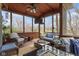 Relax in this lovely sunroom with wood ceiling, ceiling fan, large windows, and comfortable wicker furniture at 9931 Woodlands Dr, Fishers, IN 46037