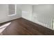 Upstairs hallway with hardwood flooring and white railing at 10453 Apple Creek Dr, Indianapolis, IN 46235