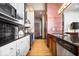 Galley kitchen with stainless steel appliances, white cabinets, and dark backsplash at 1529 N Alabama N St # B, Indianapolis, IN 46202