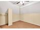 Tan carpeted attic room with tan walls and ceiling fan and a closet at 1655 Cornell Ave, Indianapolis, IN 46202