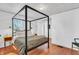 Bright bedroom features a modern, four-poster bed, wood floors, and fresh white walls at 1655 Cornell Ave, Indianapolis, IN 46202