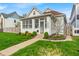Charming home featuring a beautiful front yard, walkway, landscaped garden, and a sunroom at 1655 Cornell Ave, Indianapolis, IN 46202