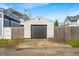 Detached garage with a dark gray door and concrete pad located next to the wooden privacy fence at 1655 Cornell Ave, Indianapolis, IN 46202