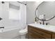 Stylish bathroom with modern vanity, round mirror, and a shower with subway tile at 1665 N College Ave, Indianapolis, IN 46202