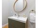 Stylish bathroom with a round mirror over a modern vanity and gold hardware at 1665 N College Ave, Indianapolis, IN 46202