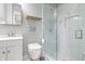Modern bathroom with a glass shower, white marble tiles, and floating shelf at 1665 N College Ave, Indianapolis, IN 46202