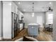 Open concept kitchen with stainless steel appliances, a marble island, and hardwood floors at 1665 N College Ave, Indianapolis, IN 46202